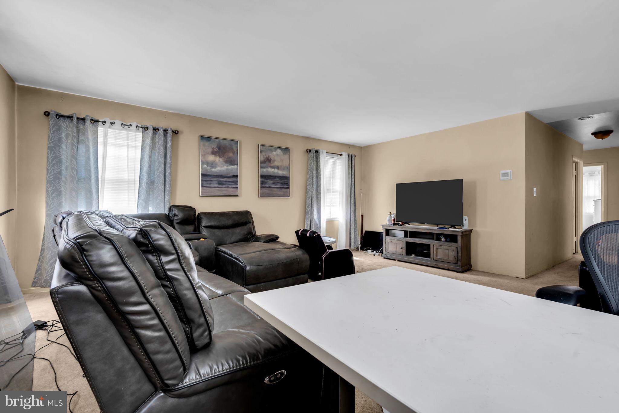 27 Genesee Lane Willingboro, NJ 08046 - Photo 9 of 25 a living room with furniture a flat screen tv and large windows