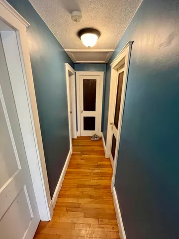 a view of a hallway with wooden floor and staircase