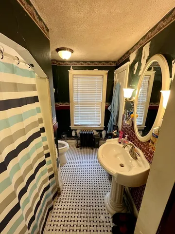 a bathroom with a sink toilet and mirror