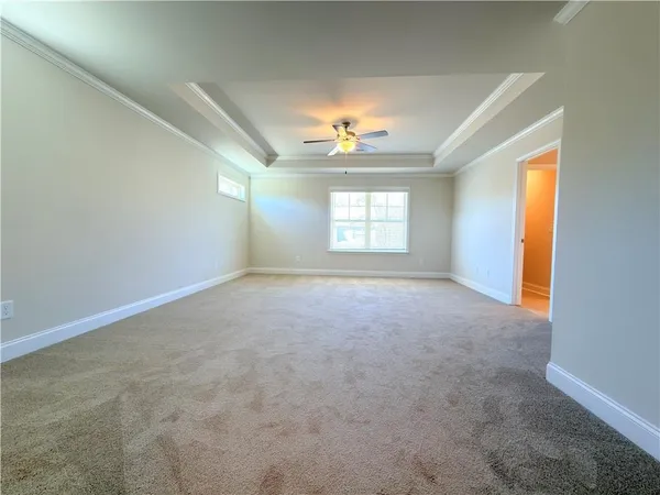 an empty room with closet and a ceiling fan