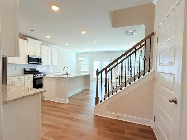 a kitchen with stainless steel appliances granite countertop a stove a sink and a microwave