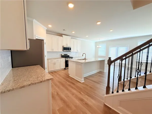 a kitchen with white cabinets stainless steel appliances and sink