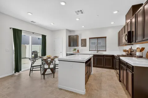 a kitchen with a table chairs refrigerator and microwave