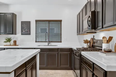 a kitchen with stainless steel appliances kitchen island granite countertop a sink and cabinets