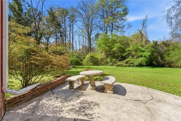 a view of a two chairs and a table in backyard of the house