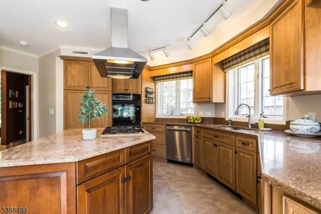 a kitchen with stainless steel appliances granite countertop sink stove and refrigerator