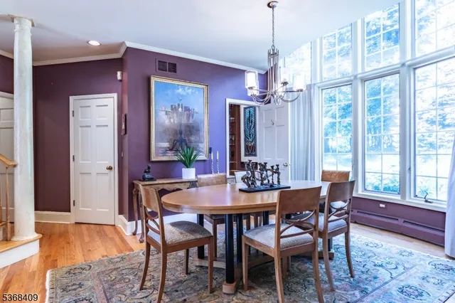a dining room with furniture a chandelier and wooden floor