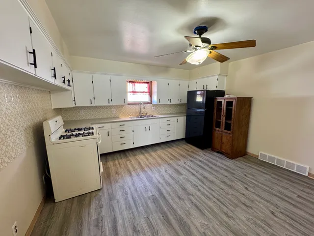 a kitchen with stainless steel appliances a stove a refrigerator and cabinets