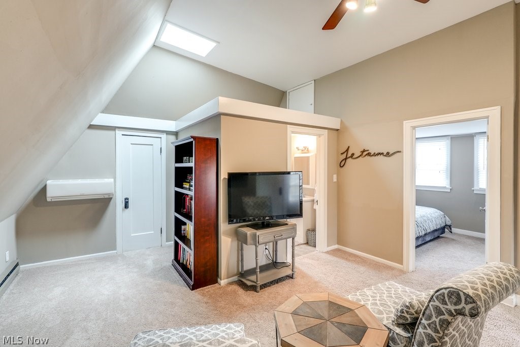 16010 Fernway Road Cleveland, OH 44120 - Photo 21 of 30 Carpeted living room featuring ceiling fan, a wall unit AC, and vaulted ceiling with skylight