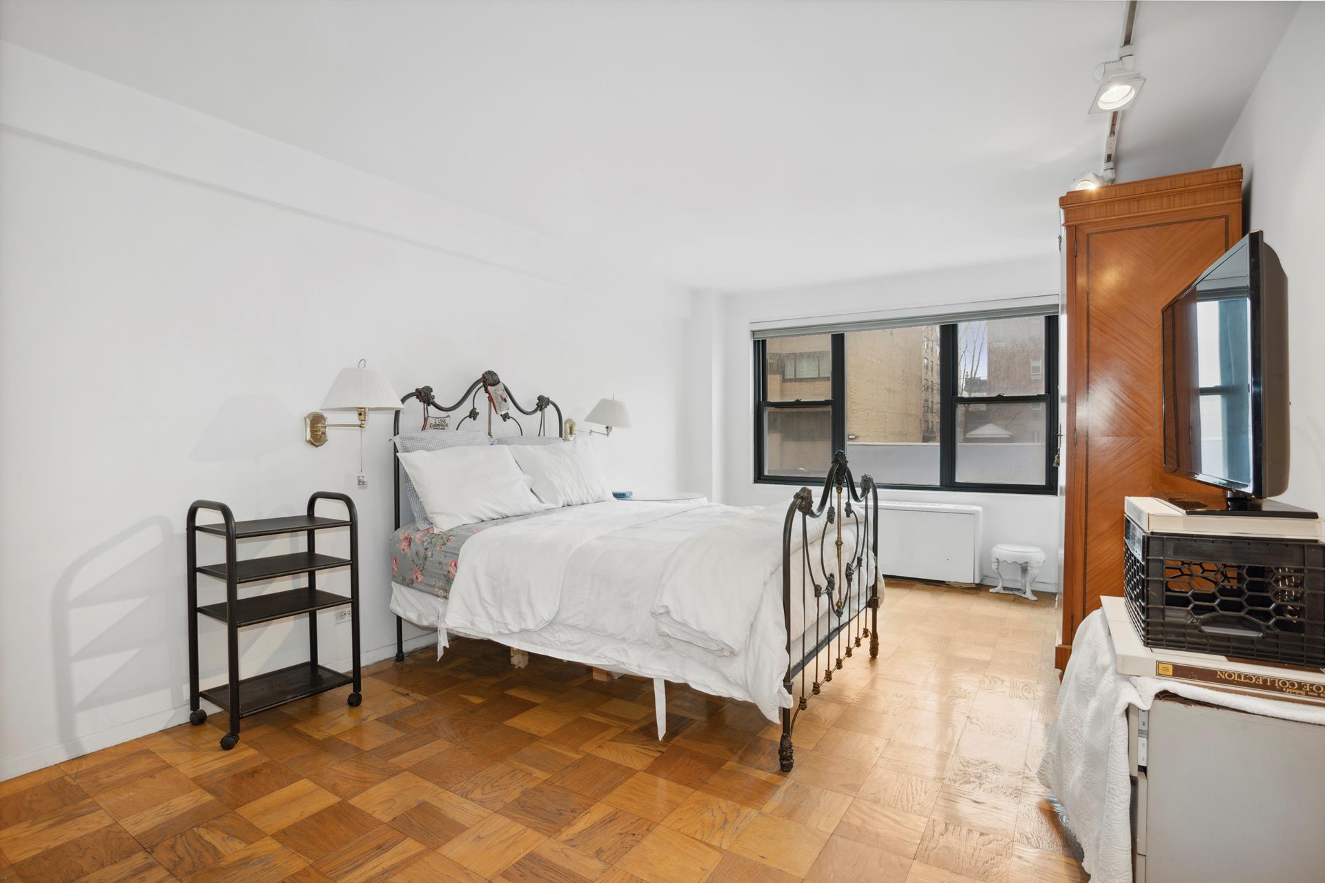 40 East 84th Street, Unit 4A Manhattan, NY 10028 - Photo 10 of 22 a bedroom with a bed and a dresser with mirror