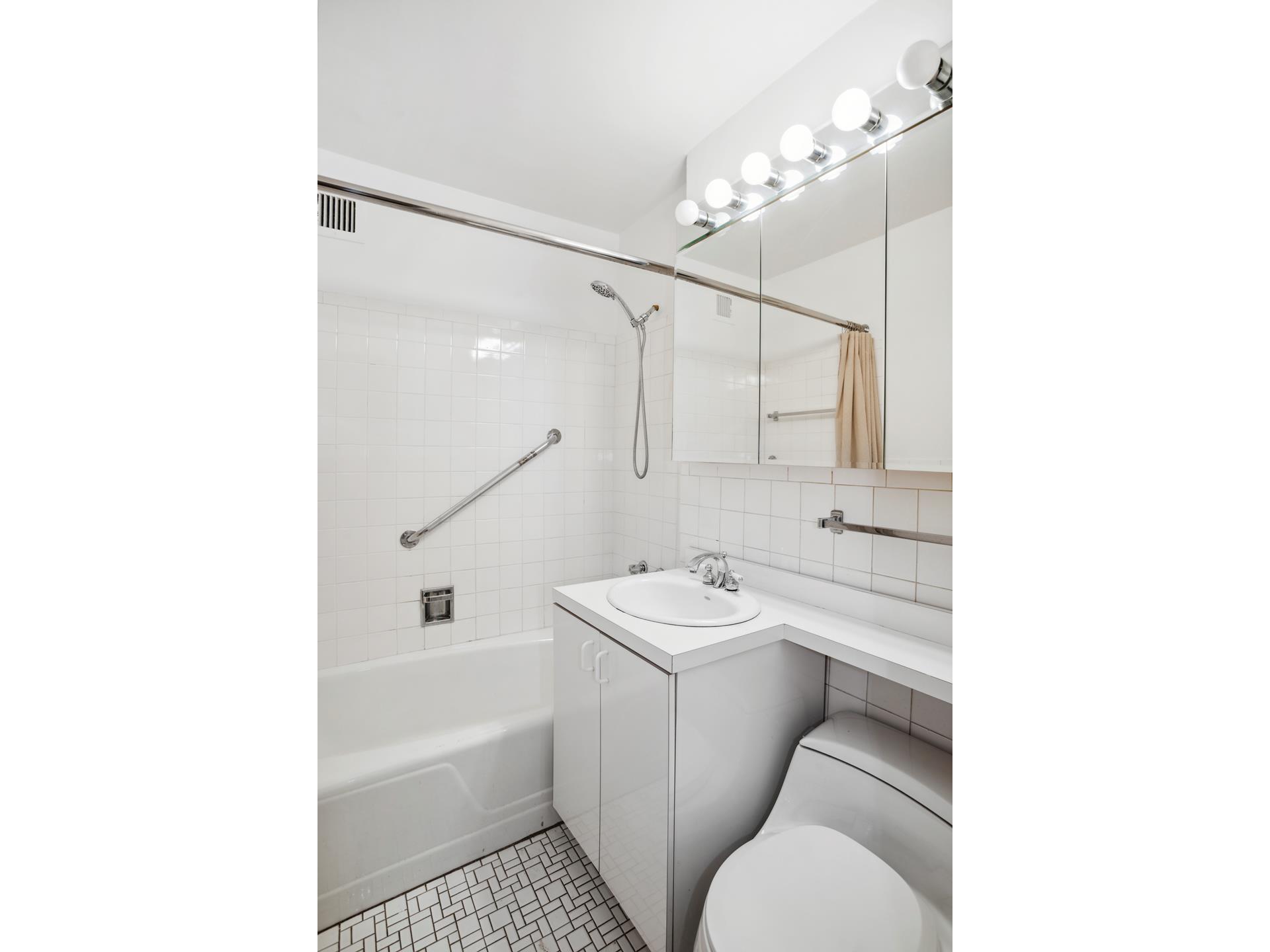40 East 84th Street, Unit 4A Manhattan, NY 10028 - Photo 12 of 22 a bathroom with a sink toilet tub and shower