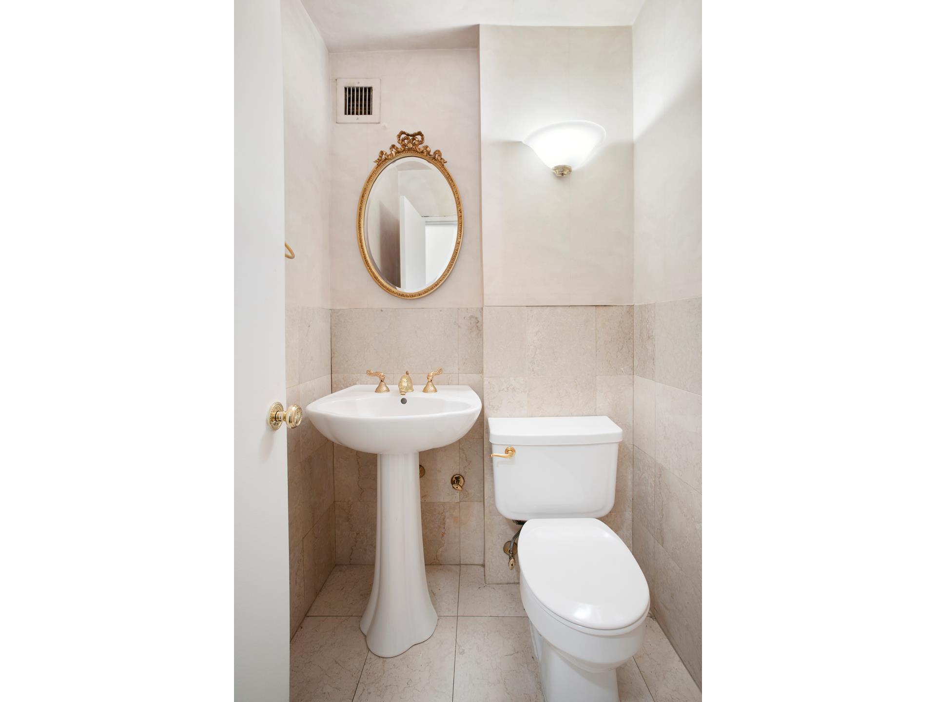 40 East 84th Street, Unit 4A Manhattan, NY 10028 - Photo 14 of 22 a bathroom with a toilet sink and mirror