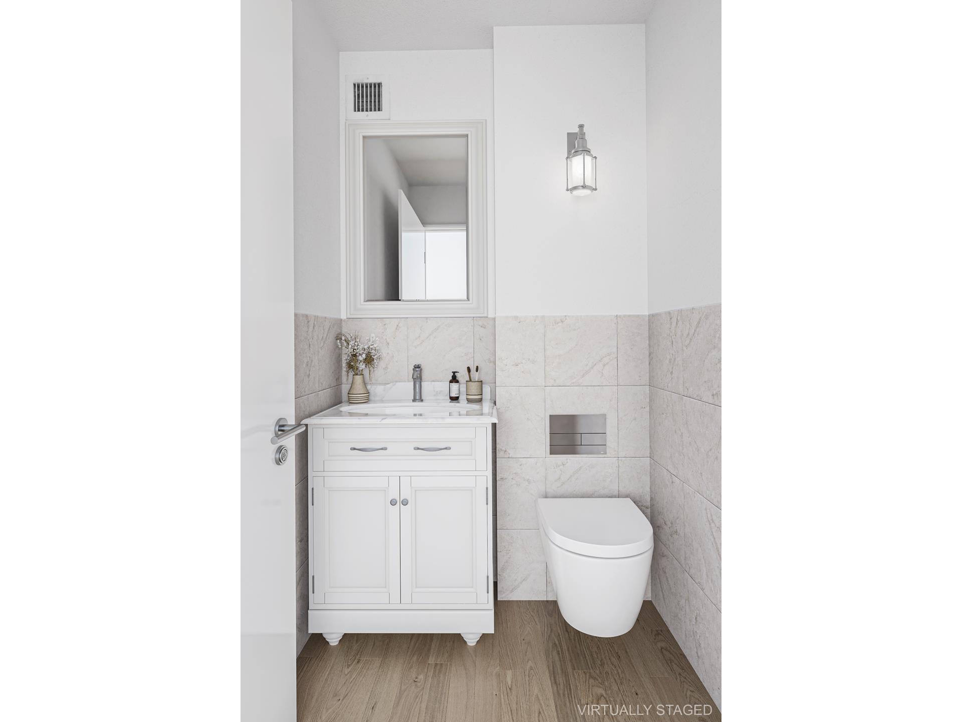 40 East 84th Street, Unit 4A Manhattan, NY 10028 - Photo 19 of 22 a bathroom with a toilet sink and a mirror