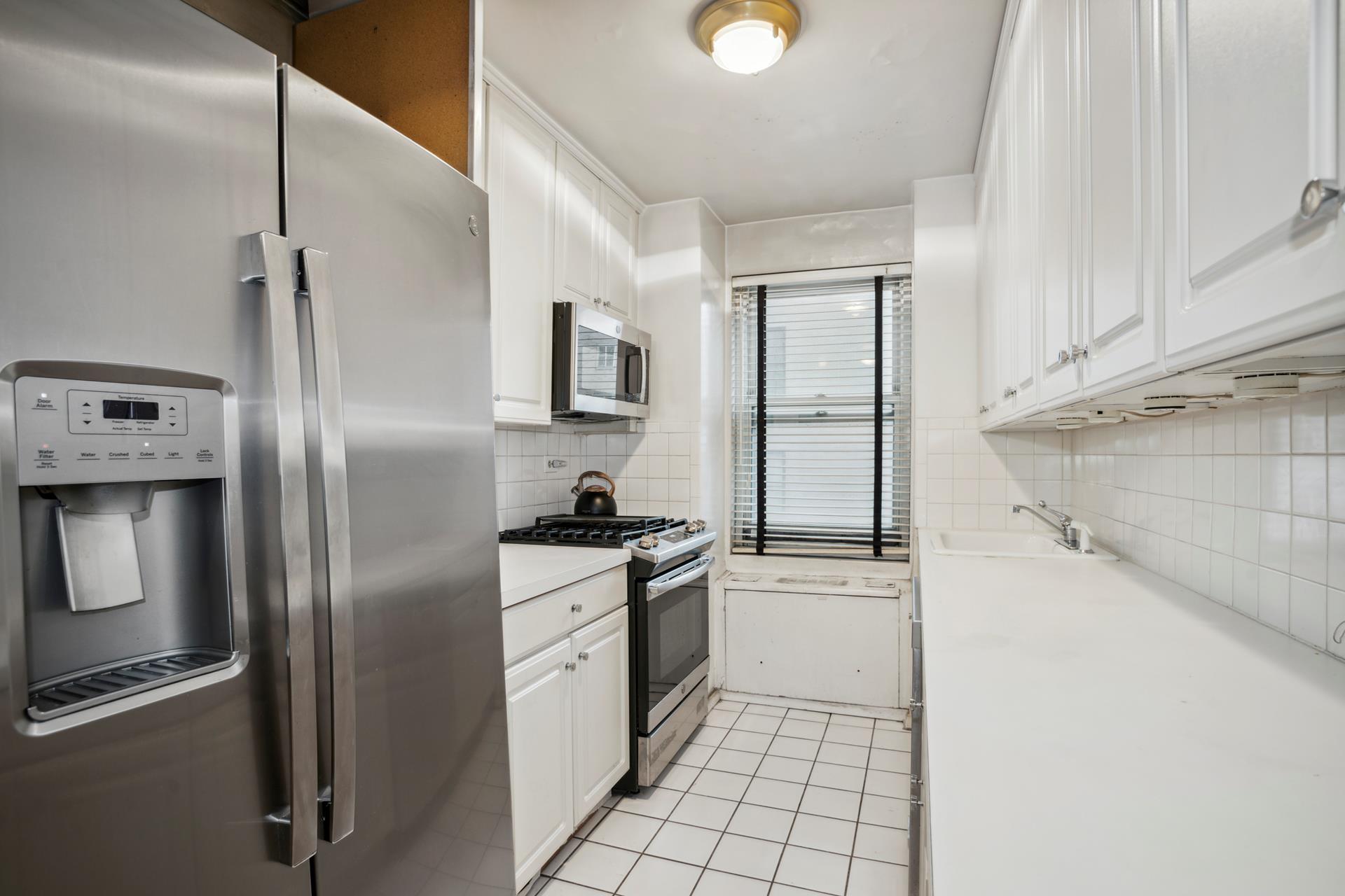 40 East 84th Street, Unit 4A Manhattan, NY 10028 - Photo 7 of 22 a kitchen with stainless steel appliances granite countertop a refrigerator a stove and a sink