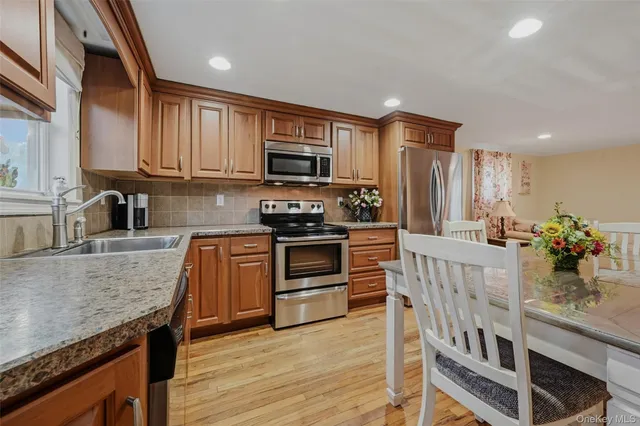 a kitchen with stainless steel appliances granite countertop a stove a sink and a microwave