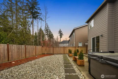 a view of a backyard with couches and wooden fence
