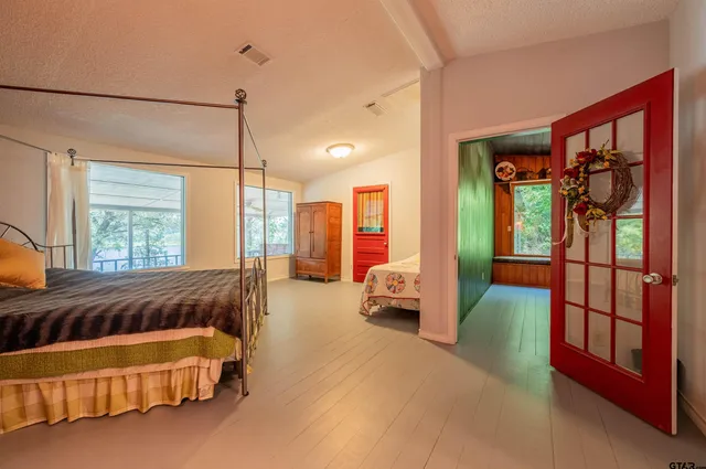 a spacious bedroom with a bed couch and a window