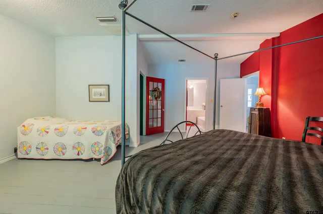 a bedroom with a bed and a painting on the wall