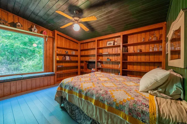 a bed sitting in a bedroom next to a large window