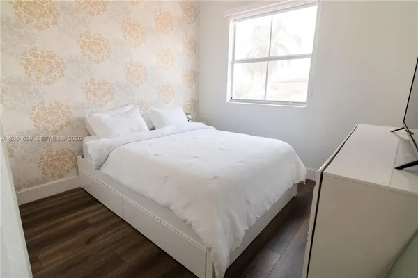 a bedroom with a bed and a flat screen tv