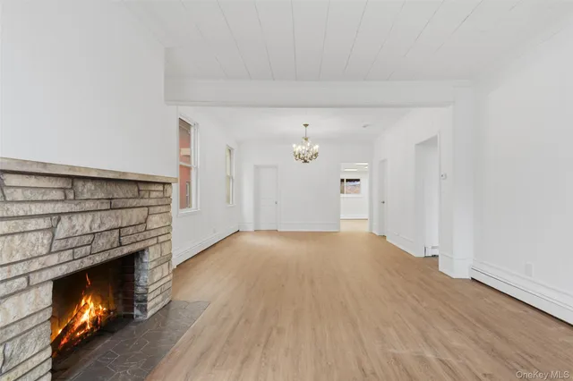 a view of empty room with wooden floor and fireplace
