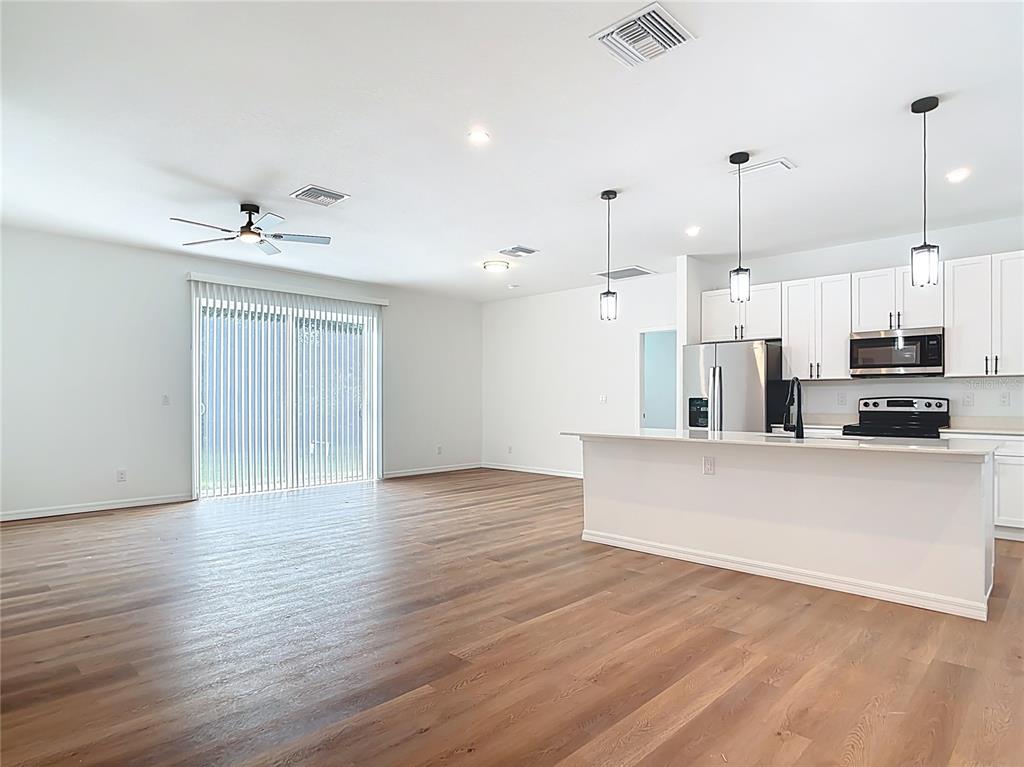 1204 Goshen Road North Port, FL 34288 - Photo 14 of 46 a view of kitchen with stainless steel appliances granite countertop a stove a sink a refrigerator and white cabinets with wooden floor