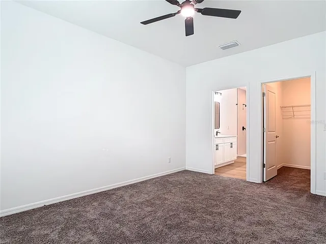 an empty room with closet and windows