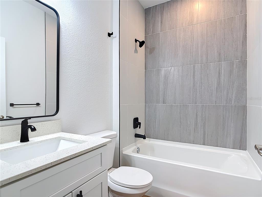 1204 Goshen Road North Port, FL 34288 - Photo 26 of 46 a bathroom with a granite countertop bathtub sink vanity mirror and toilet