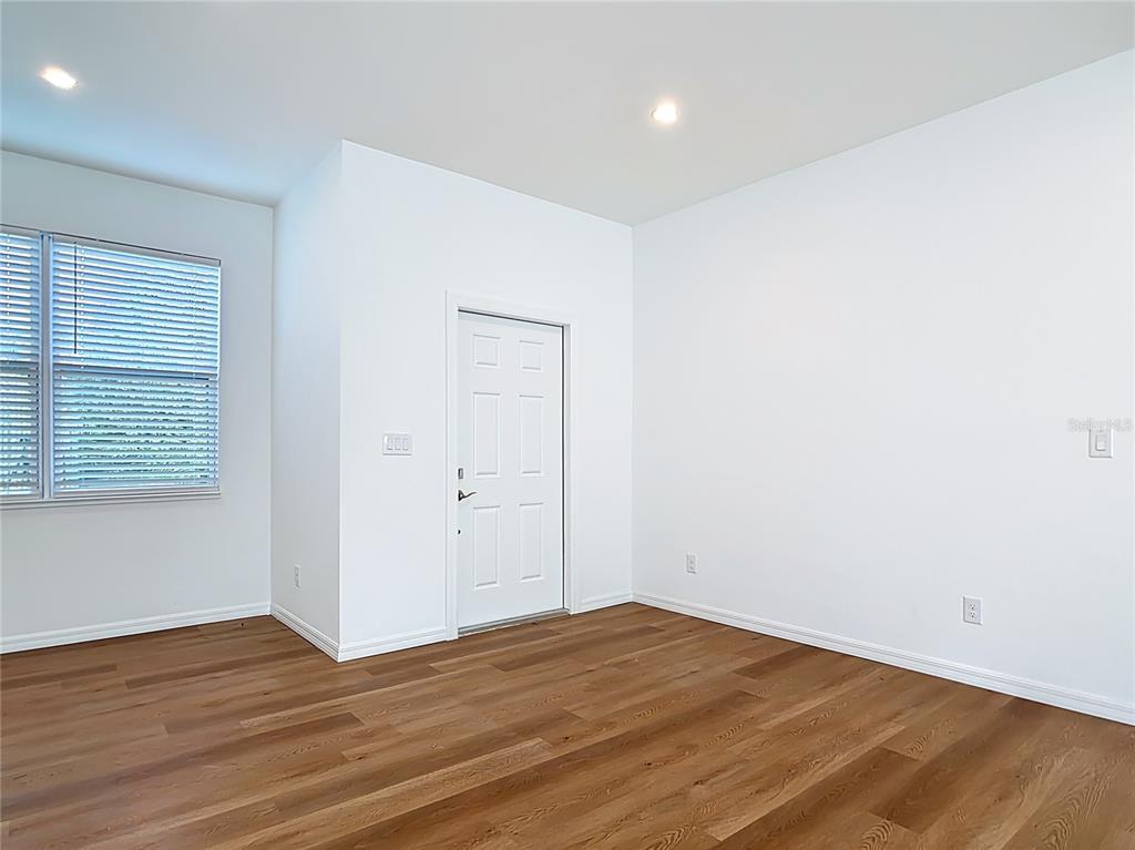 1204 Goshen Road North Port, FL 34288 - Photo 4 of 46 an empty room with wooden floor and windows