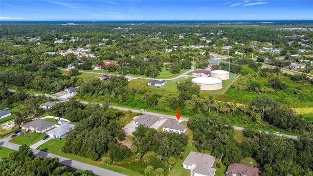 an aerial view of residential houses with outdoor space and trees