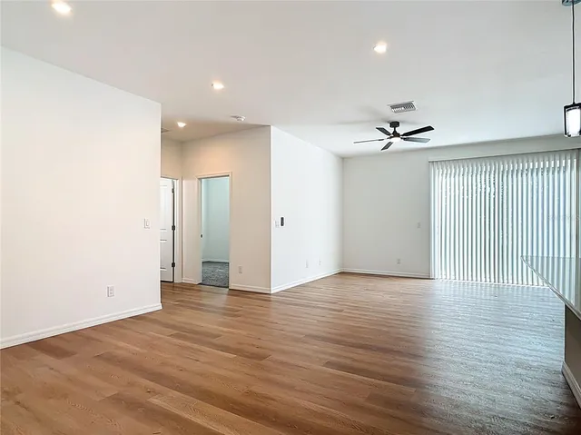 a view of an empty room with wooden floor