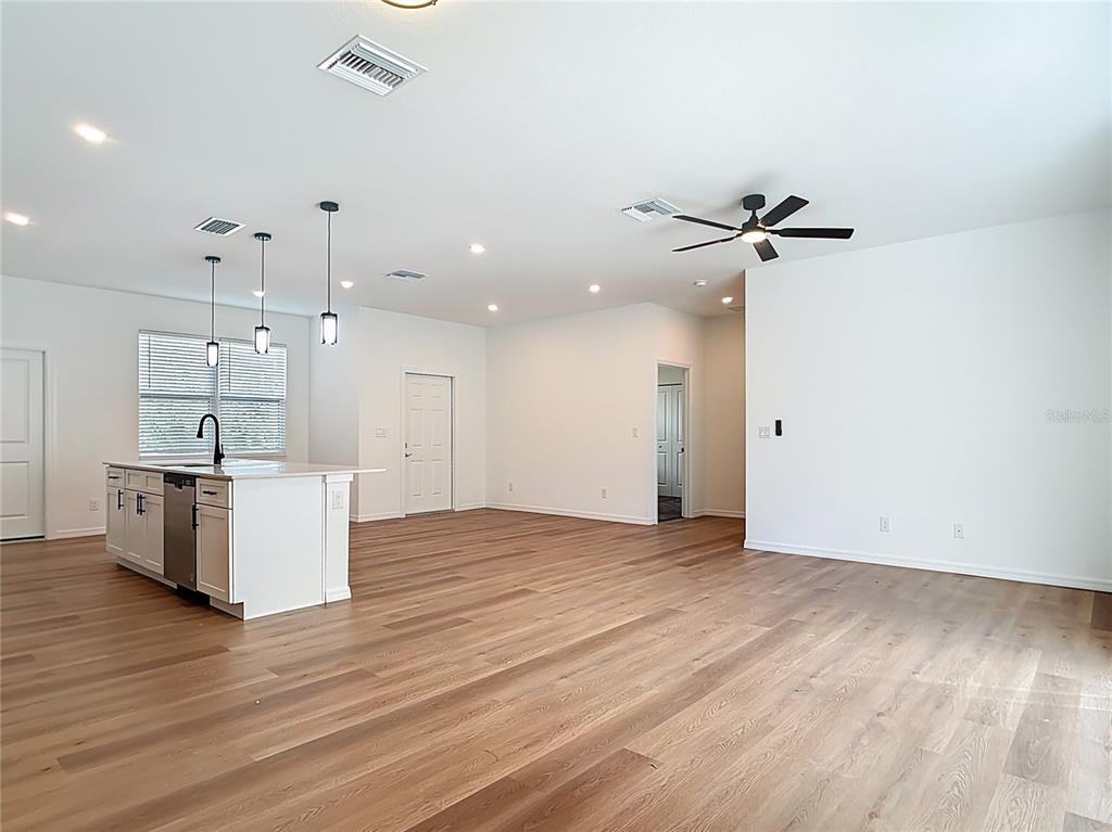 1204 Goshen Road North Port, FL 34288 - Photo 7 of 46 a view of an empty room with wooden floor and a ceiling fan