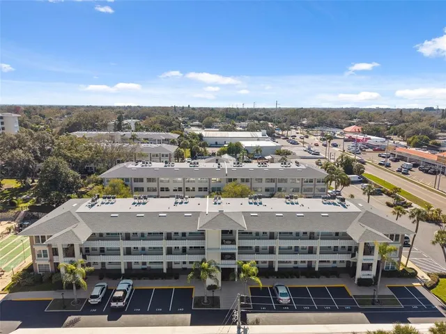 a view of yellow house with swimming pool in front of it