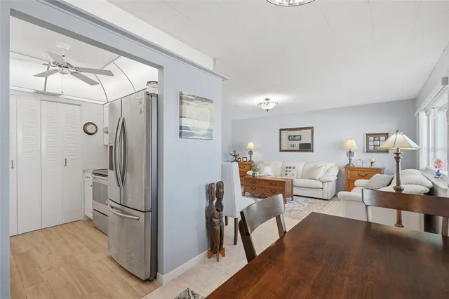 a kitchen with stainless steel appliances a refrigerator a sink and white cabinets