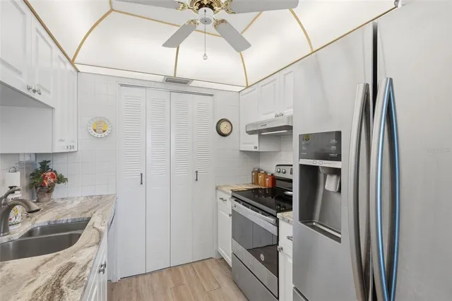 a kitchen with granite countertop a sink a stove and cabinets