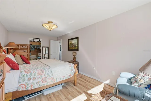 a bedroom with a bed and wooden floor