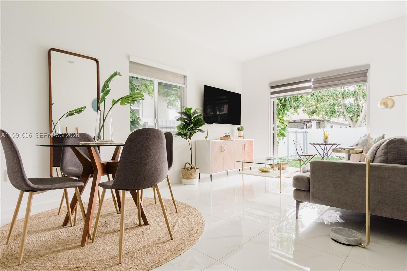 a living room with furniture a flat screen tv and a floor to ceiling window