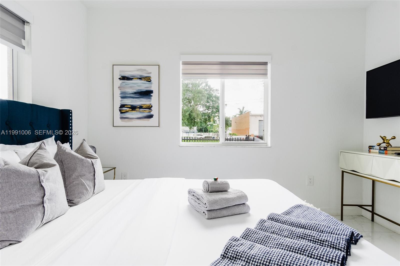 8765 Northwest 22nd Place Miami, FL 33147 - Photo 11 of 37 a bedroom with a bed and a flat screen tv