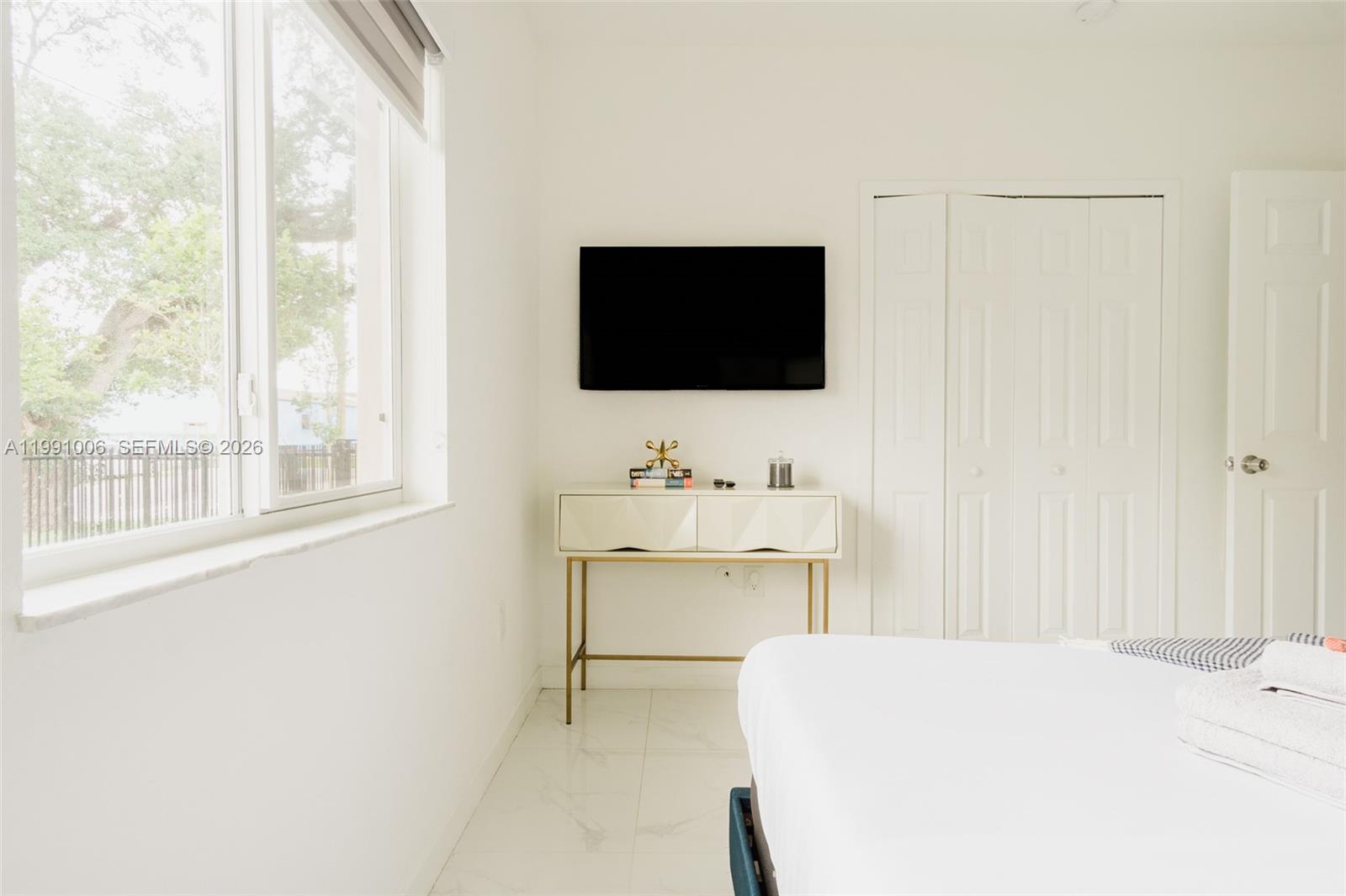 8765 Northwest 22nd Place Miami, FL 33147 - Photo 12 of 37 a room with a bed and a flat screen tv