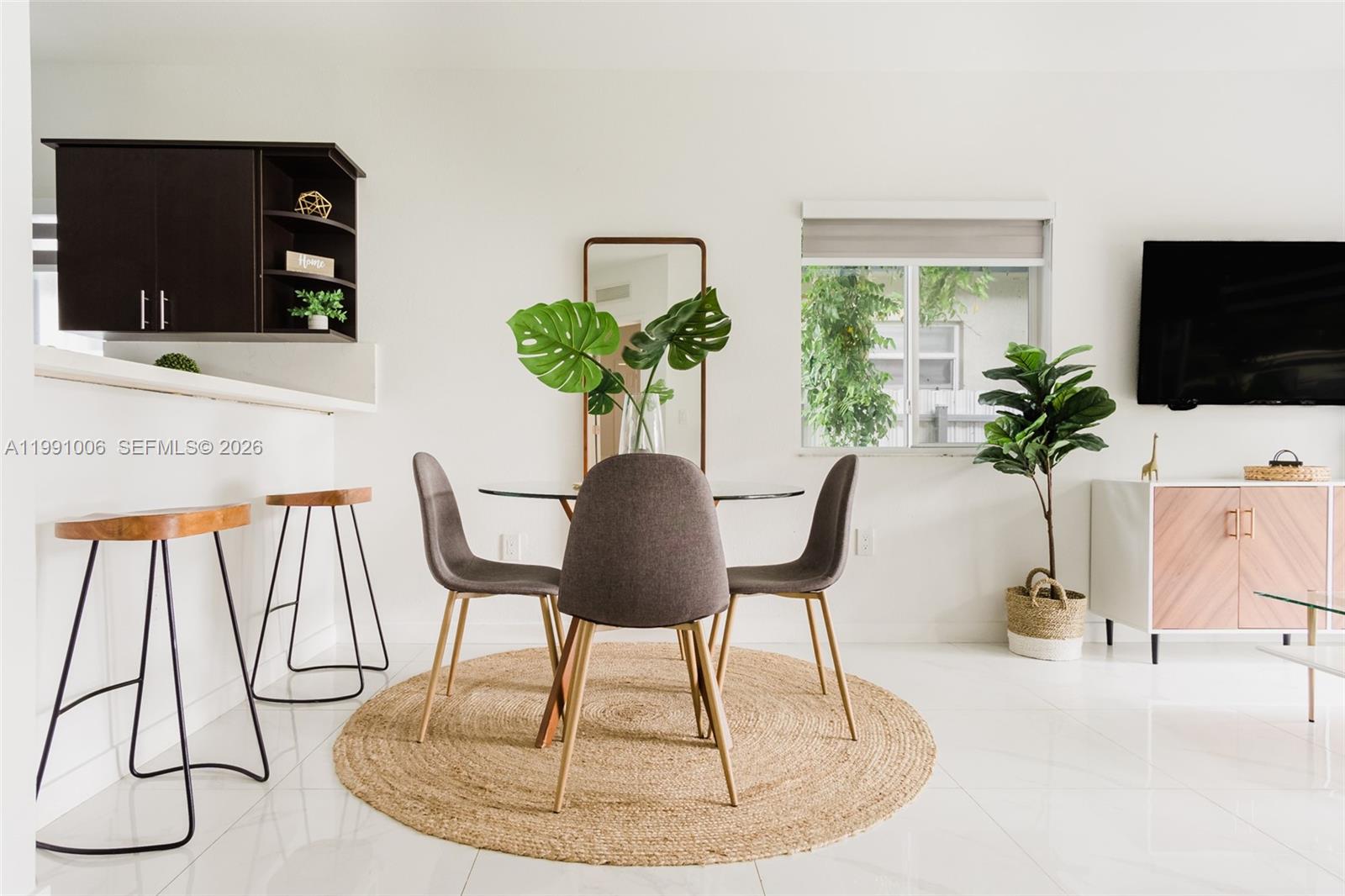 8765 Northwest 22nd Place Miami, FL 33147 - Photo 2 of 37 a vase of flowers sitting on a table with a fireplace