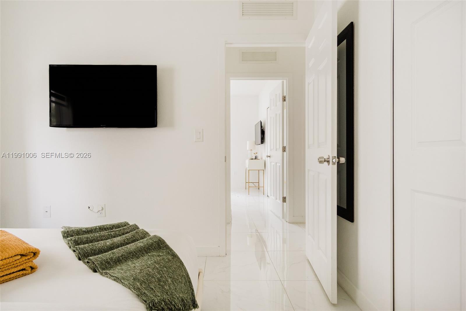 8765 Northwest 22nd Place Miami, FL 33147 - Photo 23 of 37 a bedroom with a bed and a flat screen tv