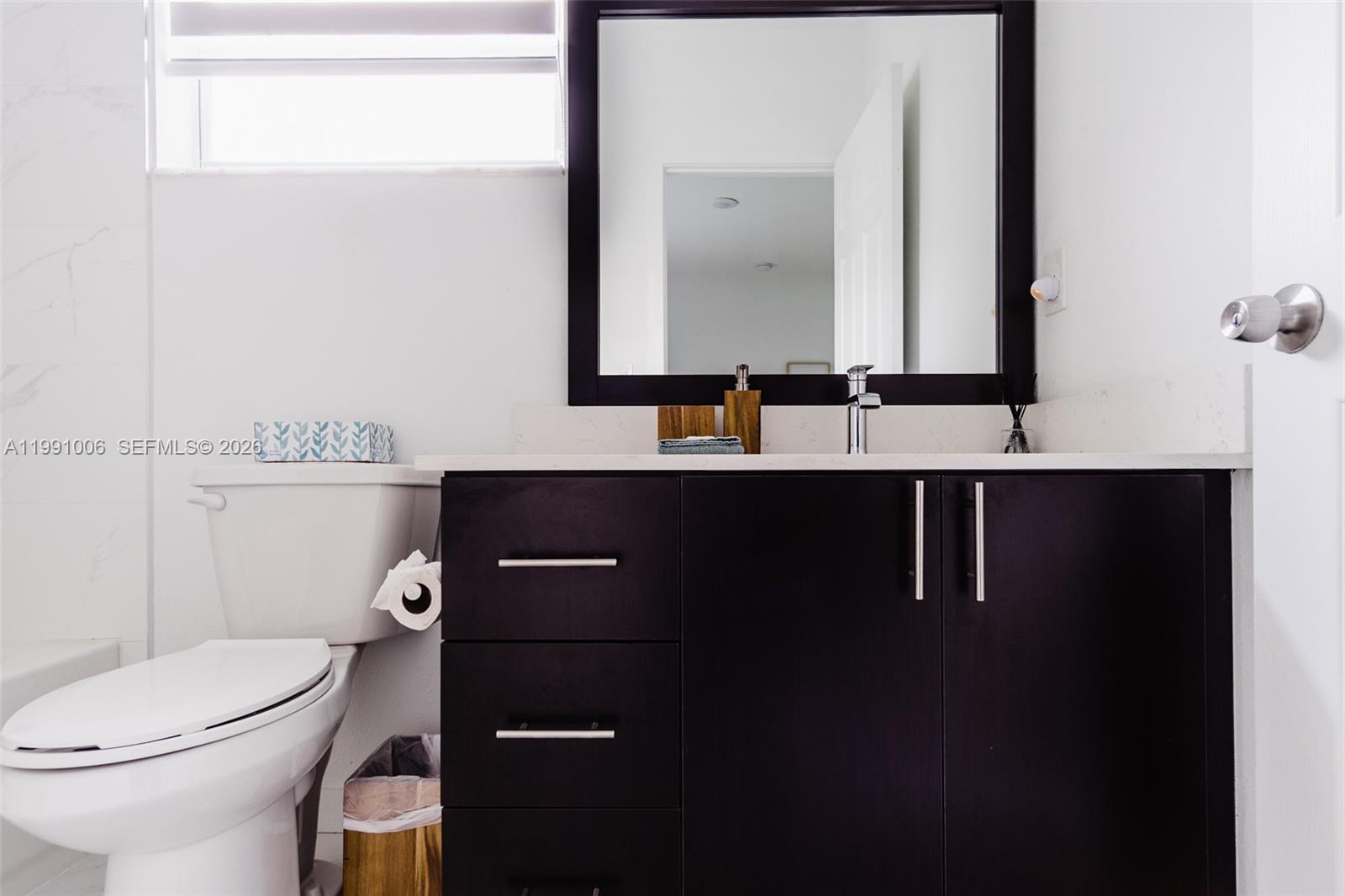 8765 Northwest 22nd Place Miami, FL 33147 - Photo 25 of 37 a bathroom with a toilet a sink and mirror