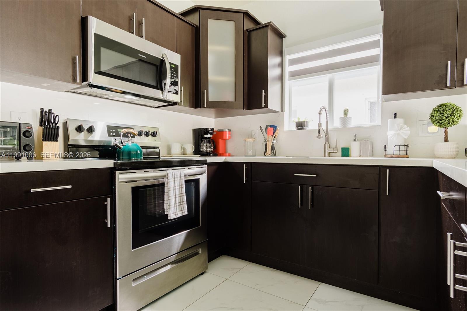 8765 Northwest 22nd Place Miami, FL 33147 - Photo 31 of 37 a kitchen with stainless steel appliances a sink stove and microwave