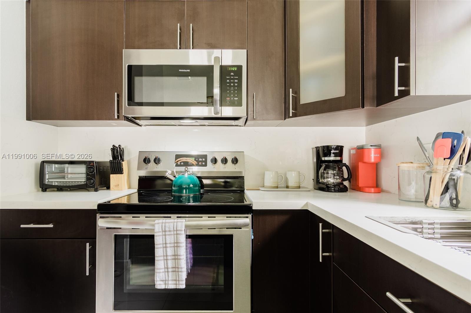8765 Northwest 22nd Place Miami, FL 33147 - Photo 32 of 37 a kitchen with stainless steel appliances granite countertop a sink stove and microwave