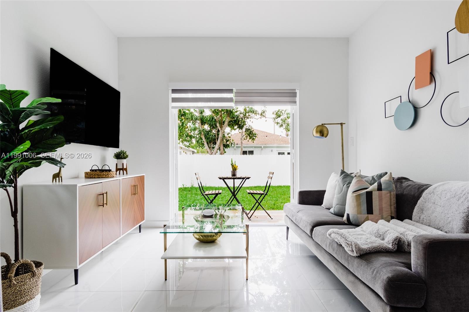 8765 Northwest 22nd Place Miami, FL 33147 - Photo 4 of 37 a living room with furniture and a flat screen tv