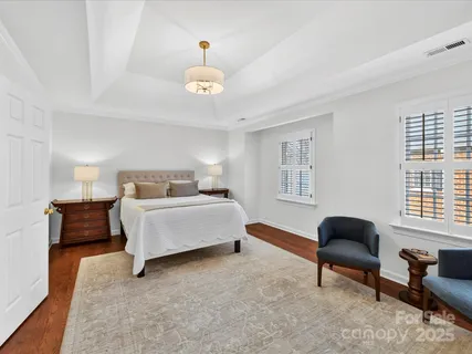 a spacious bedroom with a bed and a chandelier