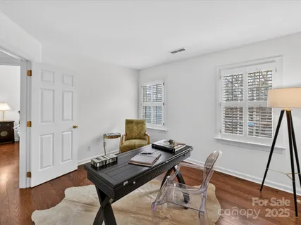 a view of a workspace with furniture and a window