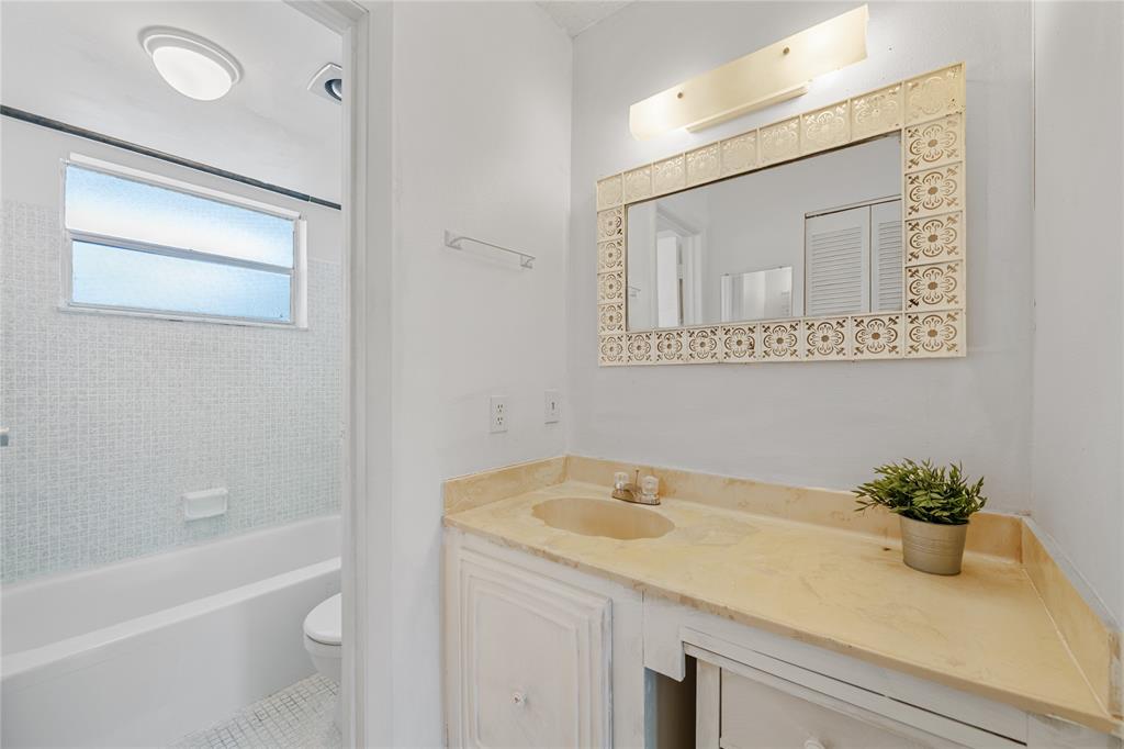 8105 Northwest 61st Street, Unit A206 Tamarac, FL 33321 - Photo 15 of 44 a bathroom with a granite countertop sink a toilet and bathtub