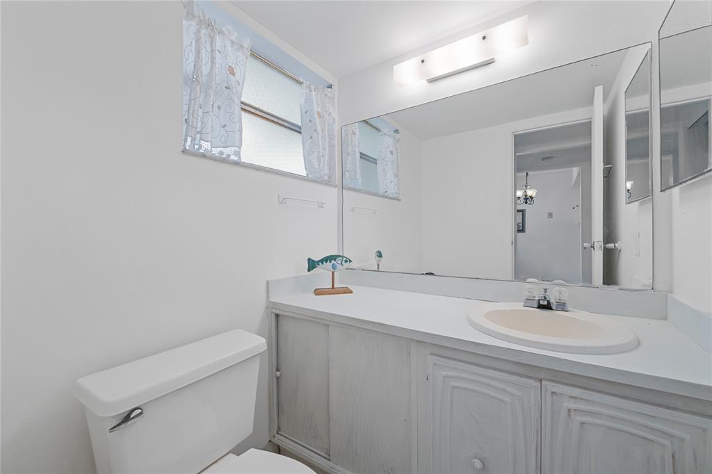 8105 Northwest 61st Street, Unit A206 Tamarac, FL 33321 - Photo 22 of 44 a bathroom with a toilet sink and mirror