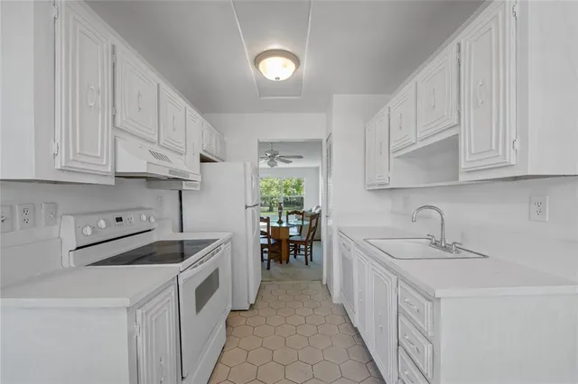 a kitchen with a stove sink and cabinets